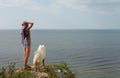 Girl and dog standing on precipice