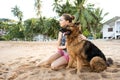 Girl with a dog on a tropical beach among palm trees and sand in Thailand Royalty Free Stock Photo