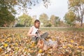 Beautiful young girl with her Yorkshire terrier dog puppy enjoying and playing in the autumn day in the park selective focus Royalty Free Stock Photo