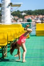 Girl doing cartwheels on Croatian ferryboat in Mali Losinj