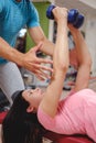 Girl doing chest flys with trainer help Royalty Free Stock Photo