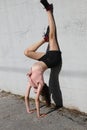 girl doing exercises sitting on the wall with her legs pointing up and hands on the ground Royalty Free Stock Photo