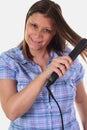 Girl doing hairstyle with hair iron Royalty Free Stock Photo