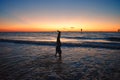 Girl doing handstand over blue sea on colorful sunset at Clearwater Beach