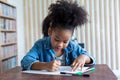 Girl is doing homework in the Classroom. Back to school! Cute industrious children are sitting at desks indoors. Kids are learning