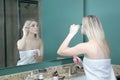 Girl doing makeup in front of mirror Royalty Free Stock Photo