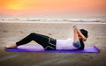 Girl doing situps on the beach at sunset Royalty Free Stock Photo