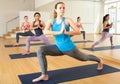 Girl doing twisting asana Parivritta Parsvakonasana in yoga studio