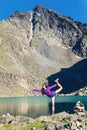 Girl doing yoga pose on a mountain lake Royalty Free Stock Photo