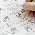 Girl doodling and making a checklist in a notebook