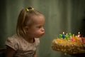 Girl with Down syndrome blows out the candles on her birthday cake Royalty Free Stock Photo