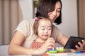 Girl with down syndrome and her mother are talking online via video call with her family, grandmother, remote congratulations Royalty Free Stock Photo