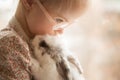 Girl with Down syndrome hugs rabbit