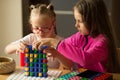 A girl with Down syndrome plays a board game with her sister