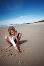 Girl drawing in beach sand Royalty Free Stock Photo