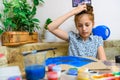 A girl drawing blue gouache cardboard, artistic creation at home, makes creative artwork