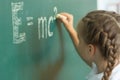 Girl drawing on chalkboard formula e mc2. Education and school concept Royalty Free Stock Photo