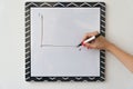 A girl is drawing a chart on a white board. Female hand with a marker Royalty Free Stock Photo