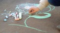 Girl drawing with colored chalk on the pavement