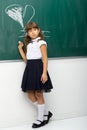 Girl drawing heart with chalk on blackboard