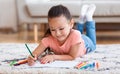 Girl Drawing Picture Using Colorful Pencils Lying On Floor Indoors Royalty Free Stock Photo