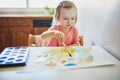 Girl drawing rainbow with colorful aquarelle paints Royalty Free Stock Photo