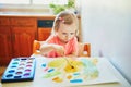 Girl drawing rainbow with colorful aquarelle paints Royalty Free Stock Photo