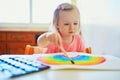 Girl drawing rainbow with colorful aquarelle paints Royalty Free Stock Photo