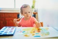 Girl drawing rainbow with colorful aquarelle paints Royalty Free Stock Photo