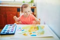 Girl drawing rainbow with colorful aquarelle paints Royalty Free Stock Photo