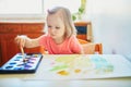 Girl drawing rainbow with colorful aquarelle paints Royalty Free Stock Photo