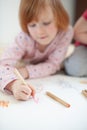 Girl draws with colored pencils lying on the floor