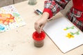 A girl draws a drawing with paints on a sheet Royalty Free Stock Photo