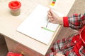 A girl draws a drawing with paints on a sheet Royalty Free Stock Photo