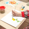 A girl draws a drawing with paints on a sheet Royalty Free Stock Photo