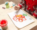 A girl draws a drawing with paints on a sheet Royalty Free Stock Photo