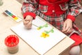 A girl draws a drawing with paints on a sheet Royalty Free Stock Photo