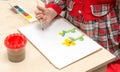 A girl draws a drawing with paints on a sheet Royalty Free Stock Photo