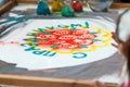 Girl draws flowers and the word `Happy holiday` on the sand, sand animation, drawing sand closeup