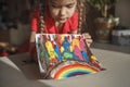 Girl draws rainbow with melted crayon pencils, she using blow dryer and wax stars to melt, art idea Royalty Free Stock Photo