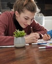 Girl drawing on a sheet of paper with pencils and markers, sitting at the table in the home kitchen Royalty Free Stock Photo