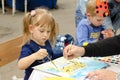 Girl draws watercolors of a leopard under the guidance of an adult artist