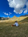 Girl with dreadlocks enjoying mountain views with her dog. Royalty Free Stock Photo