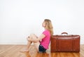 Girl dreaming and sitting next to her suitcase Royalty Free Stock Photo