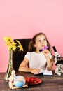 Girl with dreamy face holds purple marker. Schoolgirl at desk