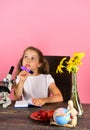 Girl with dreamy face holds purple marker. Schoolgirl at desk