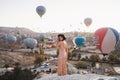 a girl in a dress on the background of balloons in Cappadocia.