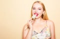 Girl in a dress on a beige background. Woman eating Philadelphia sushi. Blonde girl with red lipstick holding chopsticks for sushi Royalty Free Stock Photo