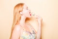 Girl in a dress on a beige background. Woman eating Philadelphia sushi. Blonde girl with red lipstick holding chopsticks for sushi Royalty Free Stock Photo