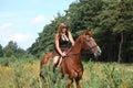 Girl in dress and brown horse portrait in forest